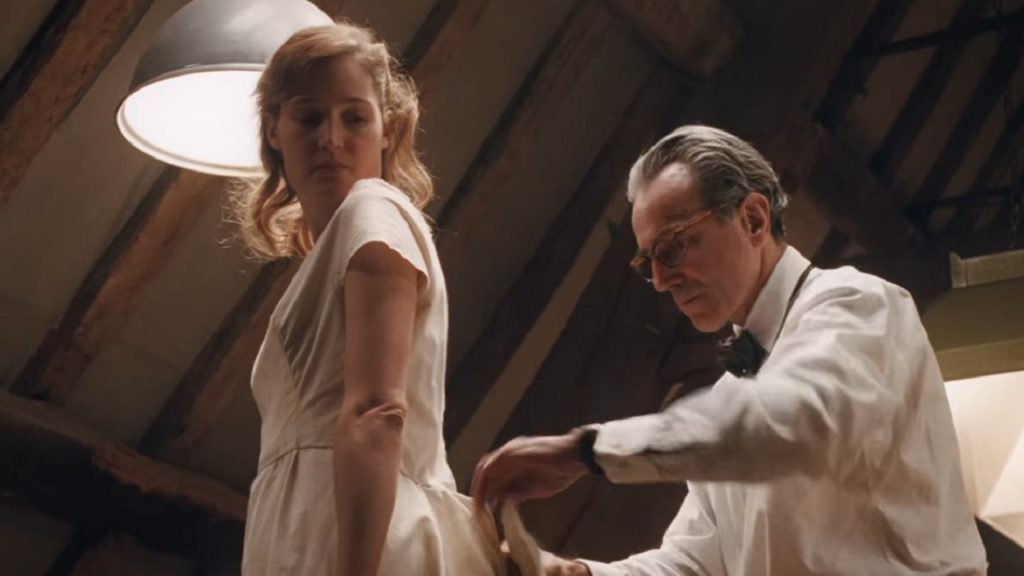 Measurements being taken for a dress in a scene from Phantom Thread.